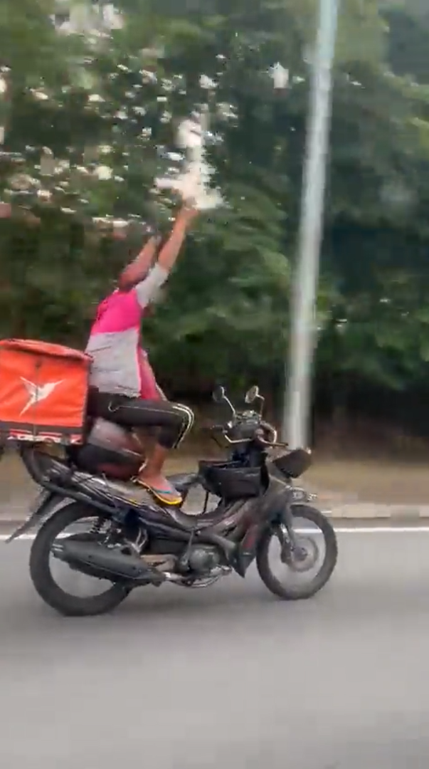 M'sian delivery rider seen riding motorbike with no hands, nabbed by police for endangering public safety