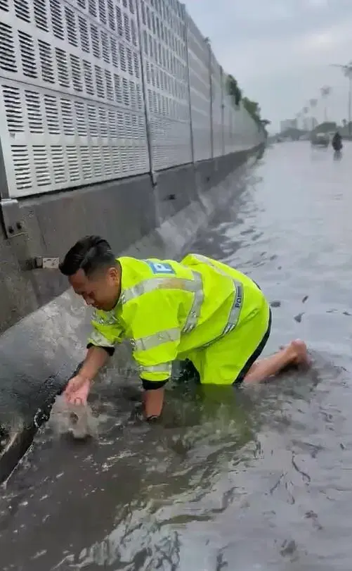 Police clear drain during flood
