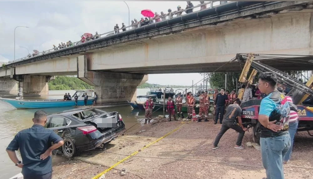 Police pulling out car from Port Dickson river