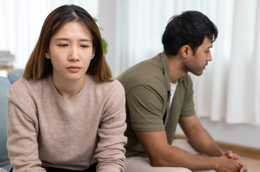 sad Asian couple on the couch