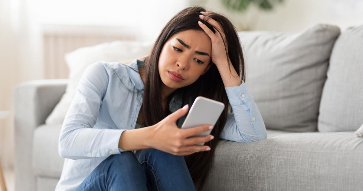 sad woman looking at her phone
