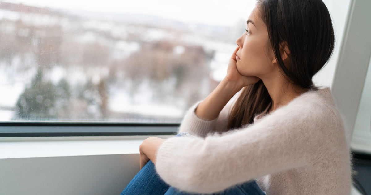 sad woman looking at that window