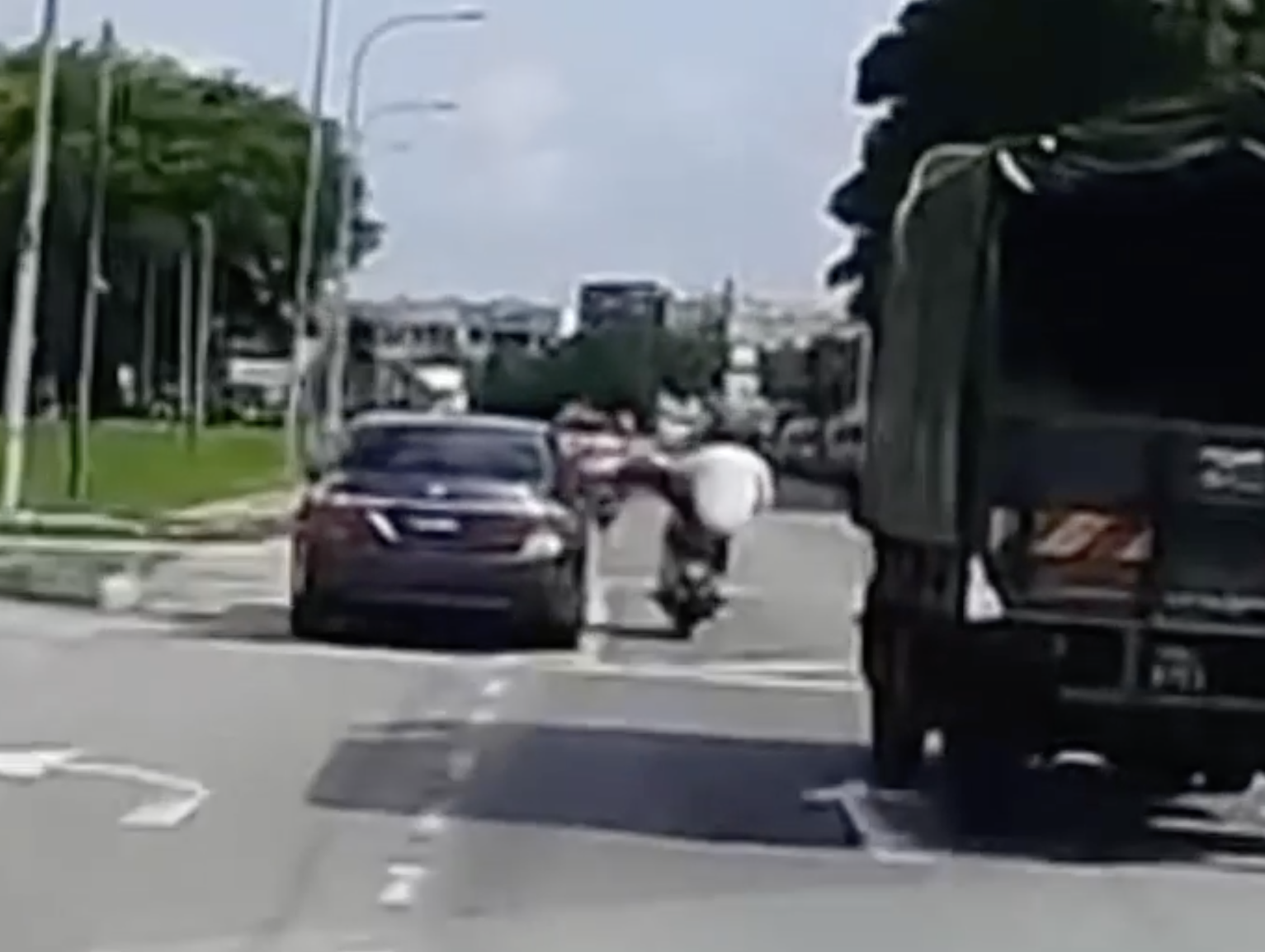 Penang motorcyclist nearly crushed by lorry after kicking a car which almost hit him | weirdkaya