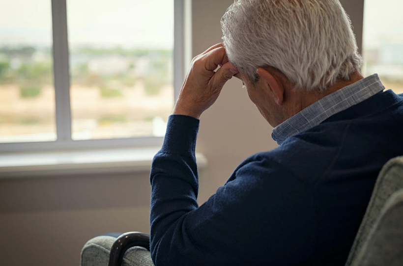 Old man looking stressed sitting on a couch