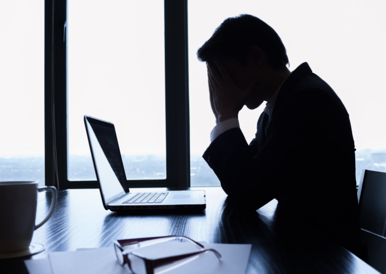 Stressed man looking at his laptop