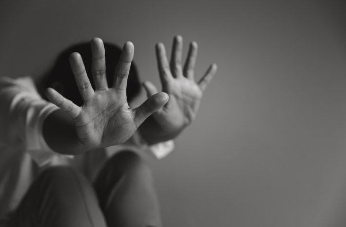 Woman covering her face with outstretched hands