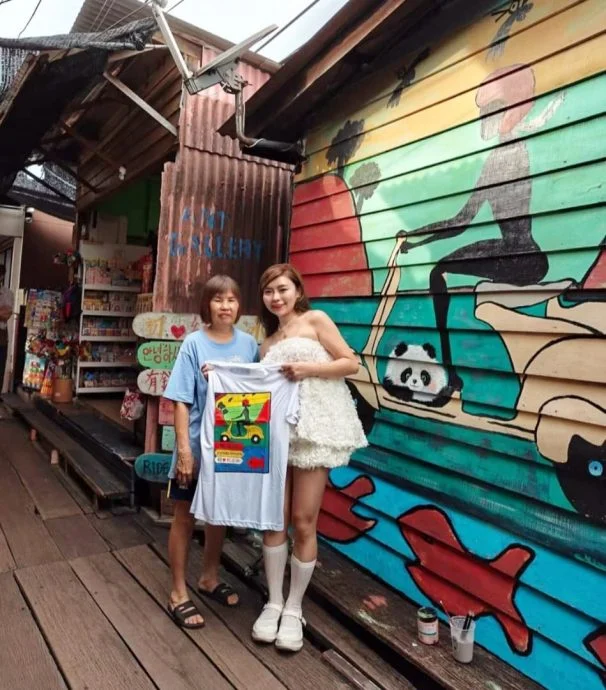 Shen posing with Chew's sister at Chew Jetty mural