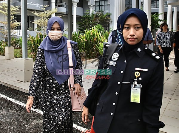 Siti Hajar escorted by police