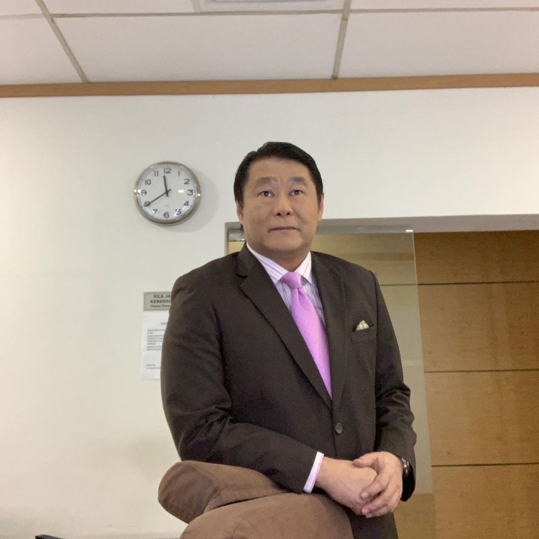 Newscaster raymond goh standing in a room