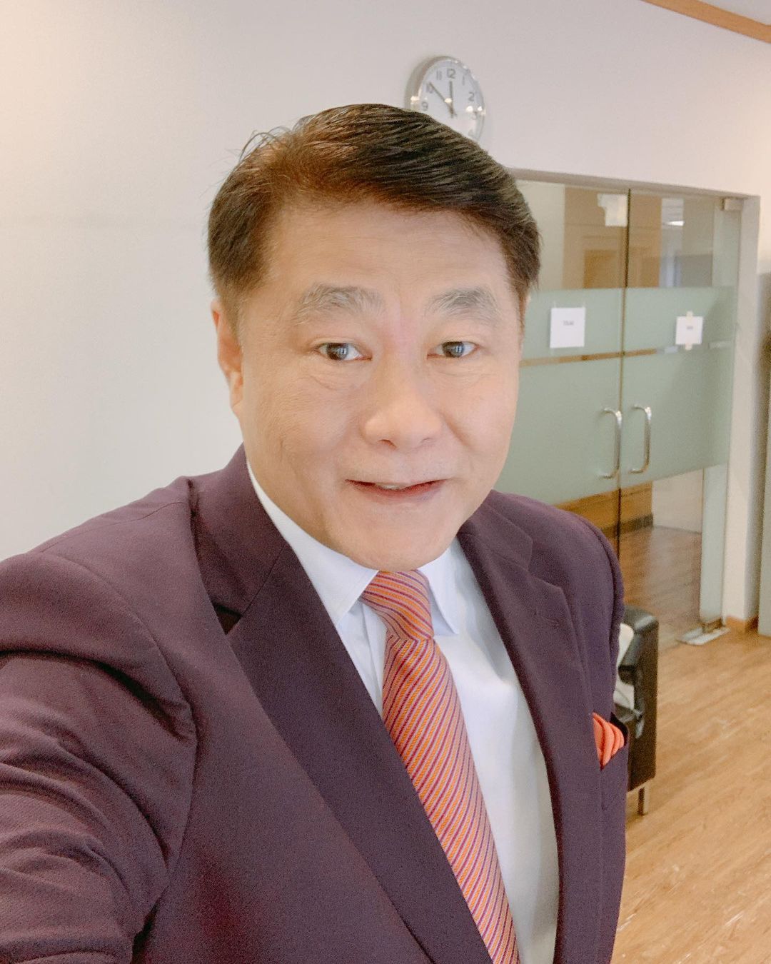 Newscaster raymond goh taking selfie in a office