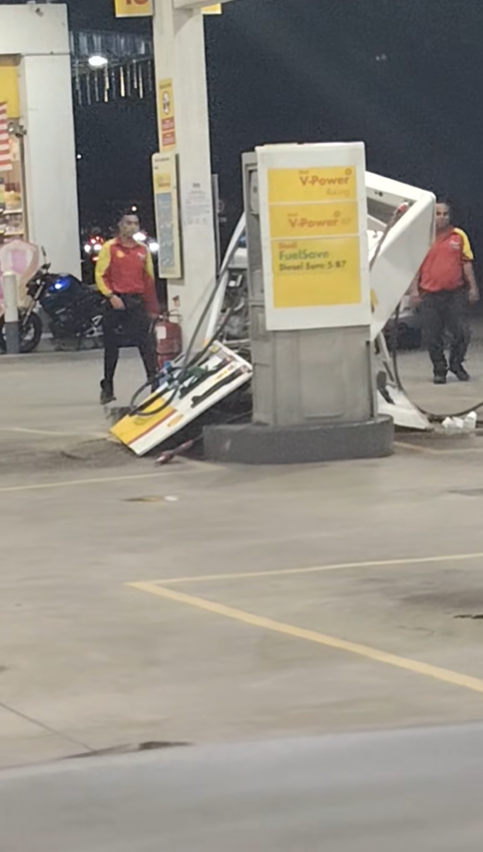 Staff walking towards damaged fuel pump in Johor