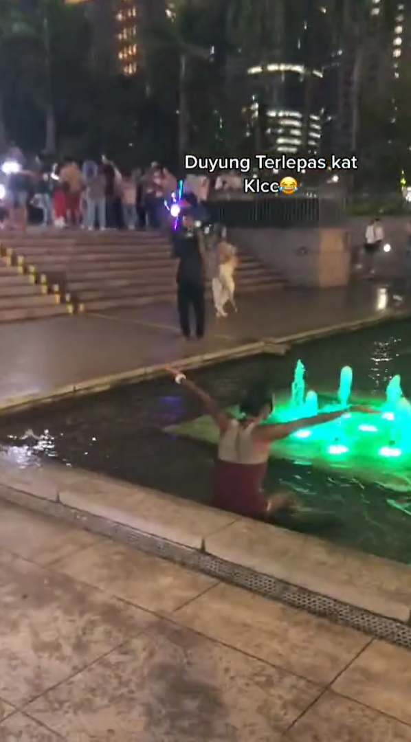 Woman in a short dress swims inside water fountain near klcc, bystanders yell ‘out! ’ at her