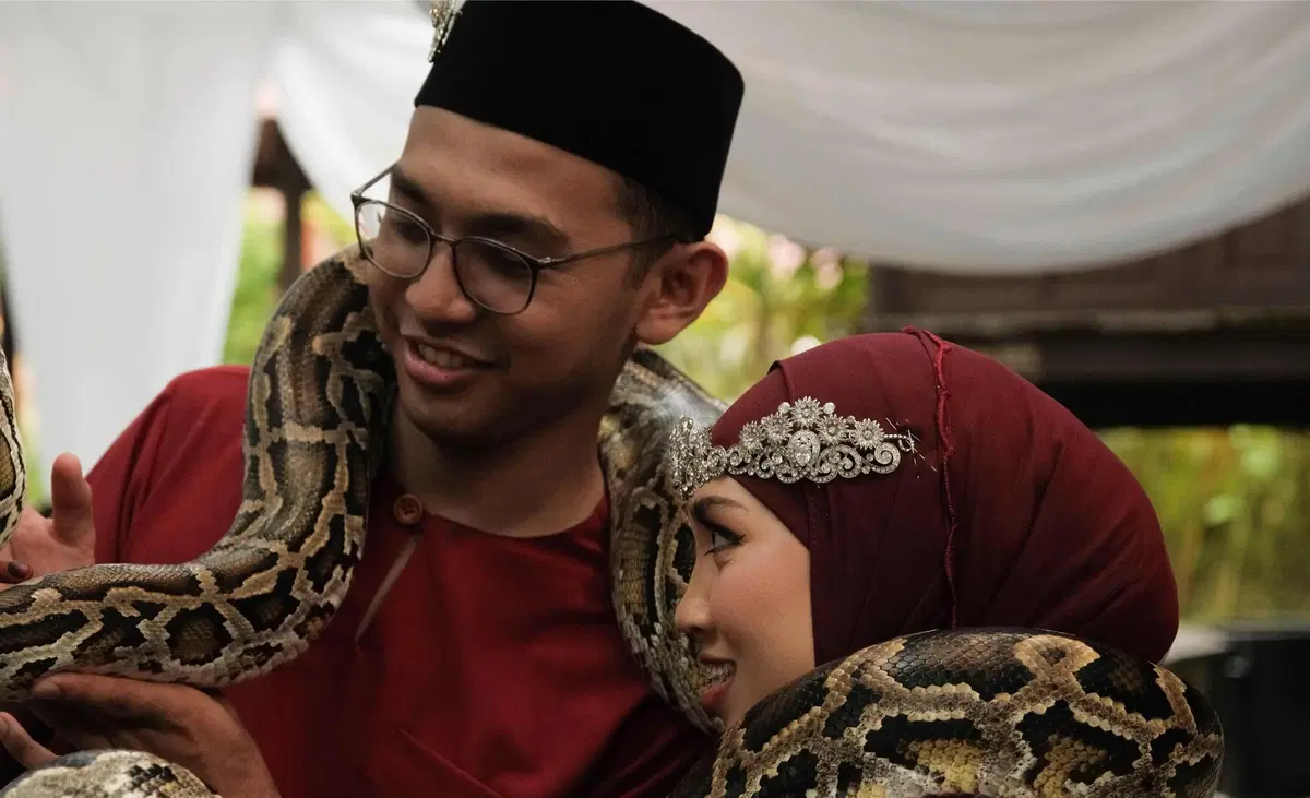 The couple with a snake around their neck