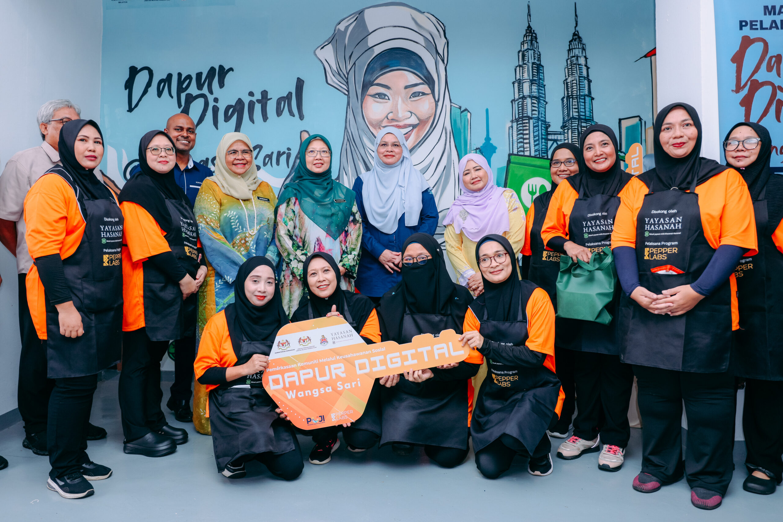 The dignitaries are seen handing over the mock key to dapur digital wangsa sari, marking the official opening of the cloud kitchen initiative aimed at empowering local micro-entrepreneurs.