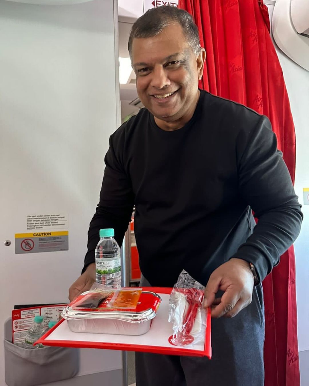 Tony fernandes poses with serving tray