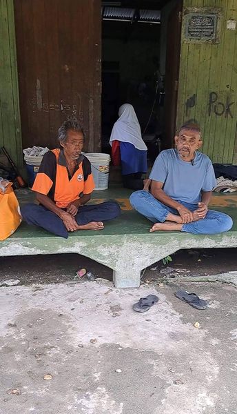 Two men sitting outside of the house