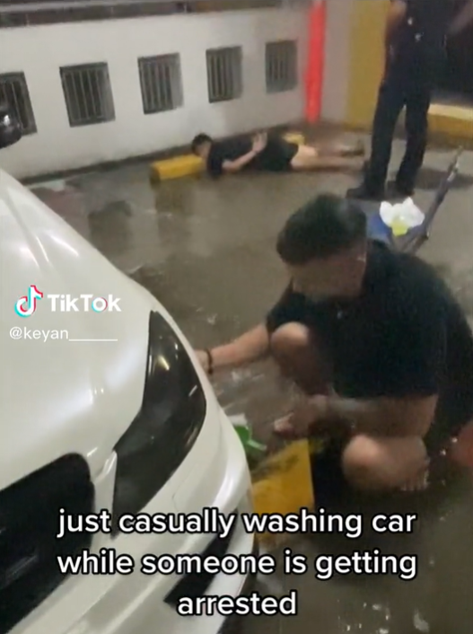 Sg man continues to wash car calmly as another man gets arrested at car park