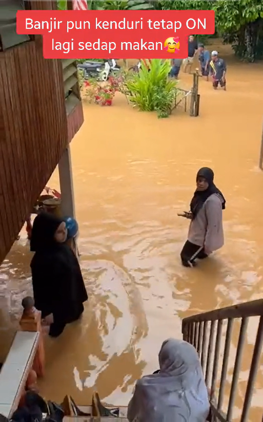 Wedding guests walk through floodwater in kedah