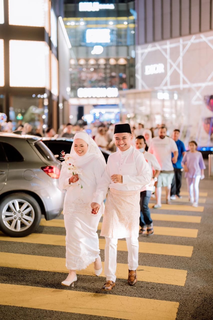 Newlyweds posing in front of pavilion kl