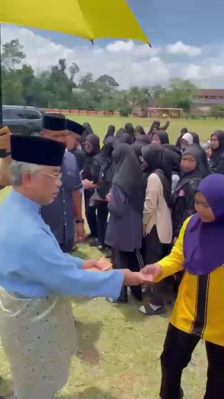 Agong handing out donations to pahang students