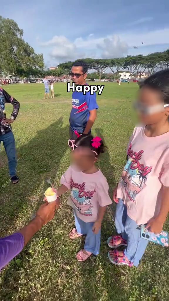 Msian ice cream vendor giving out free ice cream to children at a park