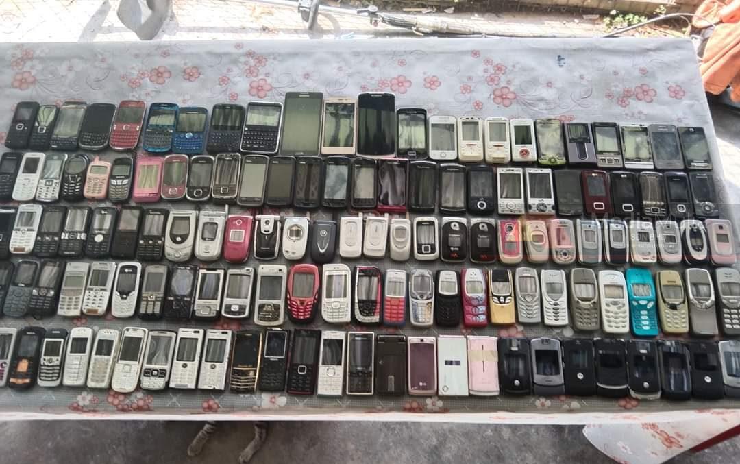 Old phones displayed on a table