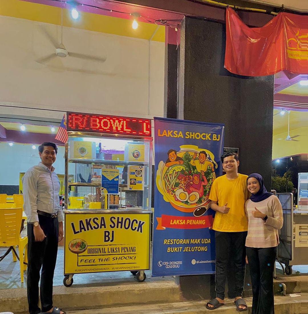 Msian man and his family members standing in front of their mee rebus stall