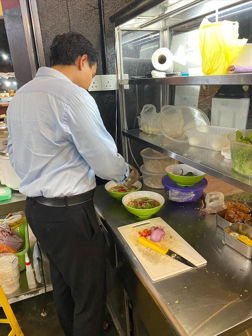 Msian man making mee rebus at his stall