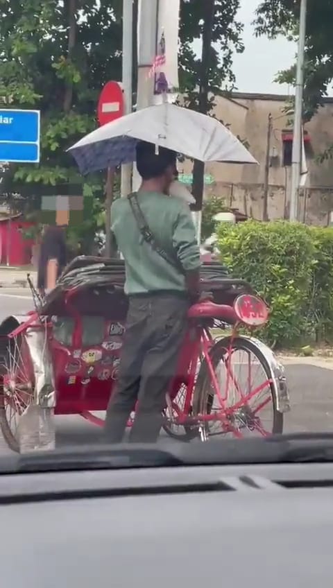 Trishaw rider sniffing glue publicly on a road