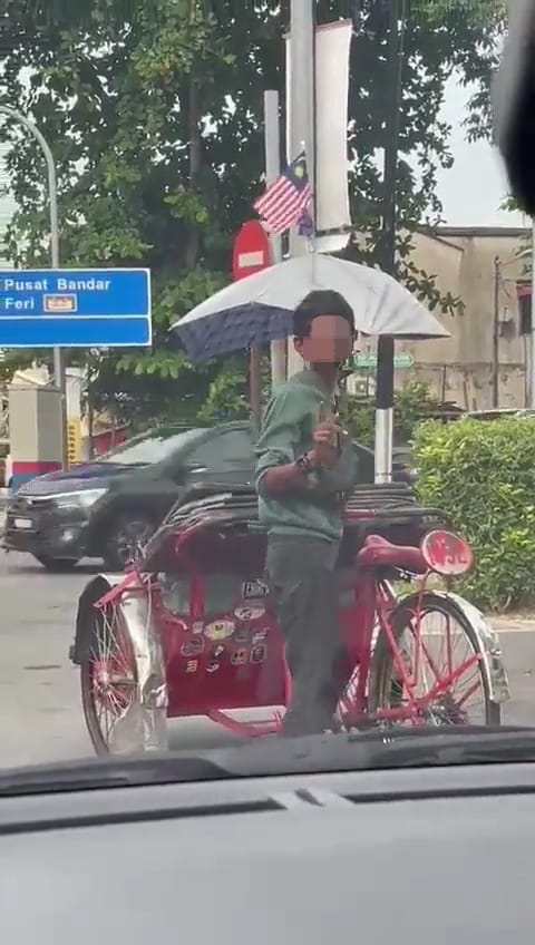 Trishaw rider looking back after been recorded by a person