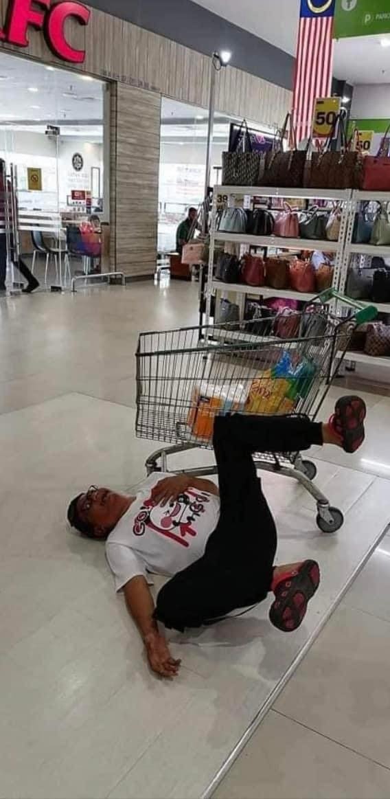 A msian man fell on the ground in a shopping mall