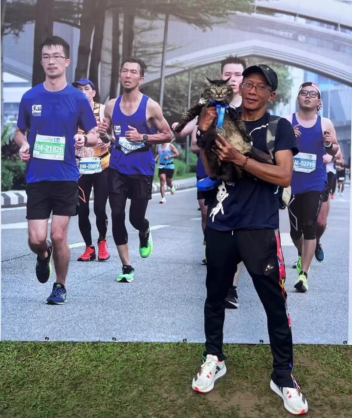 Azhan and his cat jibek after completing the 10km run.