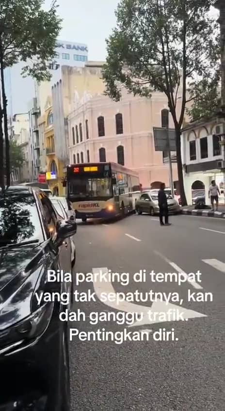 The rapidkl bus is honking directing teh car owner to move their cars