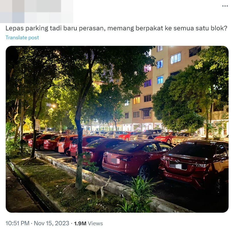 A lineup of red cars in front of an apartment.