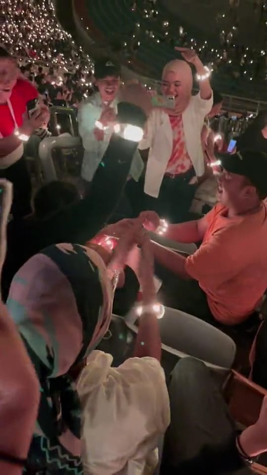 Msian man wearing the ring onto his girlfriend's finger after she said yes.
