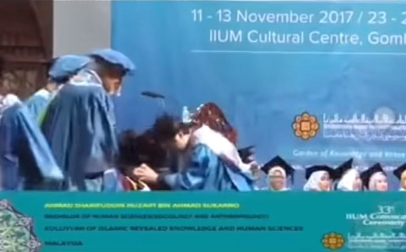 Iium graduate receiving scroll