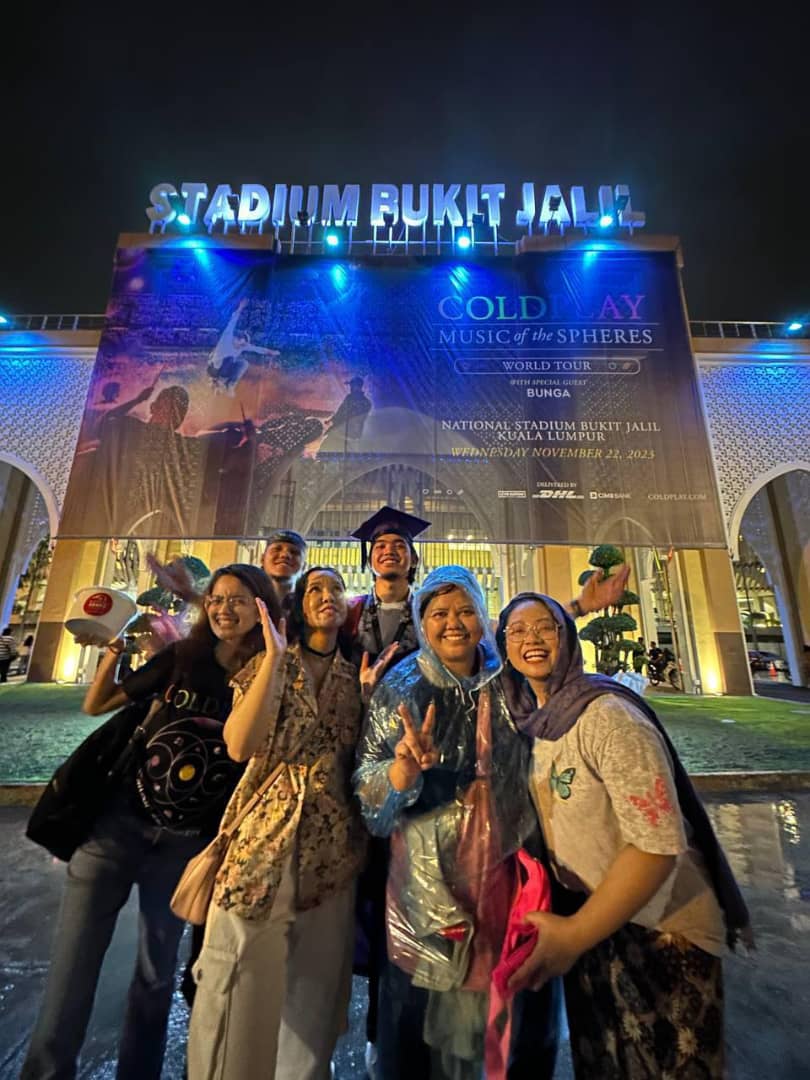 Msian graduate along with his friends taking photo outside the national stadium after coldplay concert ends.