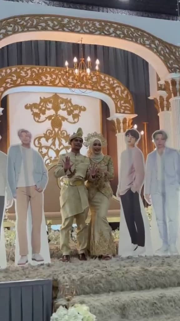 M'sian couple taking photo with bts standees at their wedding reception.