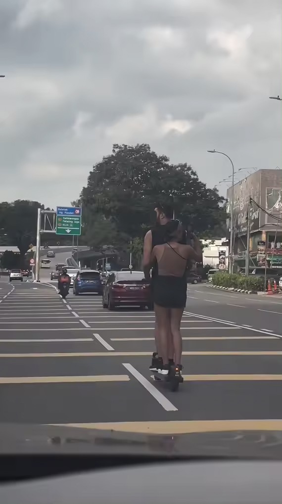 Woman films scenery while on scooter in kl
