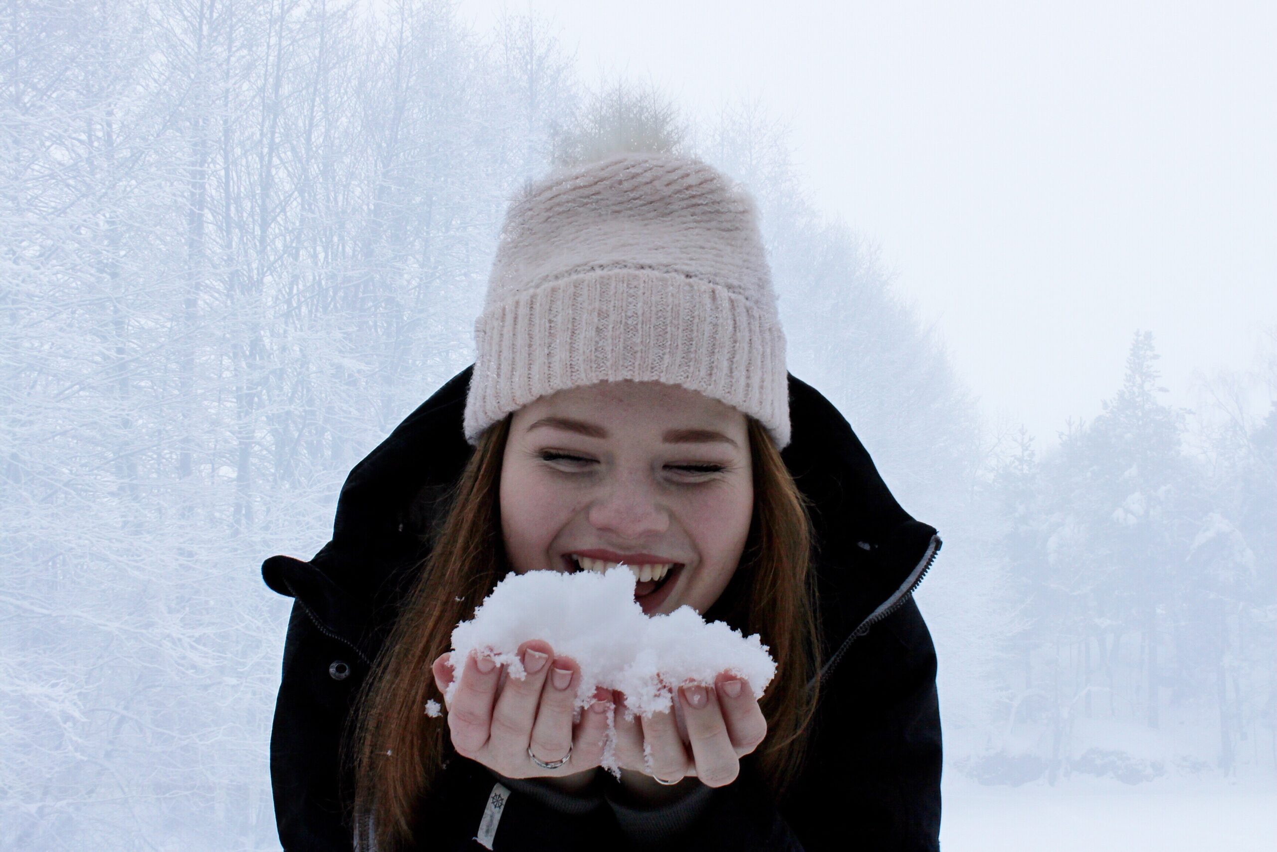 Young woman holding snow in her hands