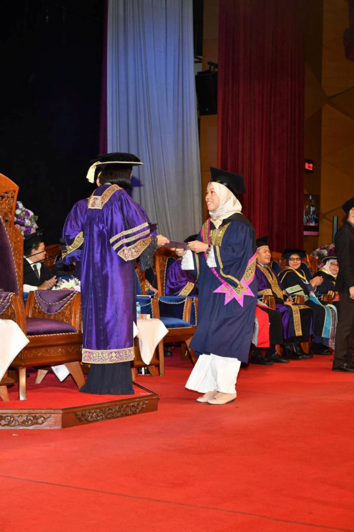 Woman receiving scroll at graduation event