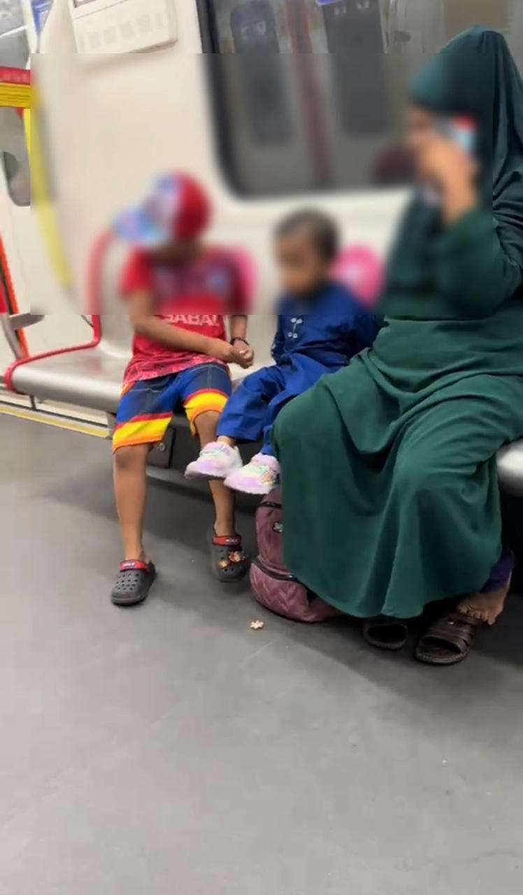 woman with kids sitting at lrt