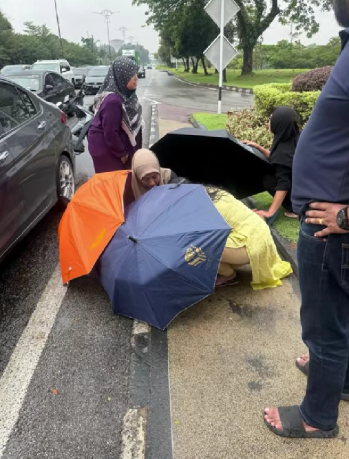 women helping a mother to deliver a baby on the road