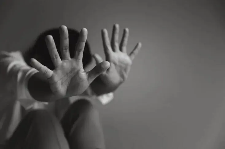 Young girl covering her face with hands